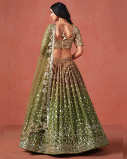 Woman wearing a green and gold traditional outfit with a plain background