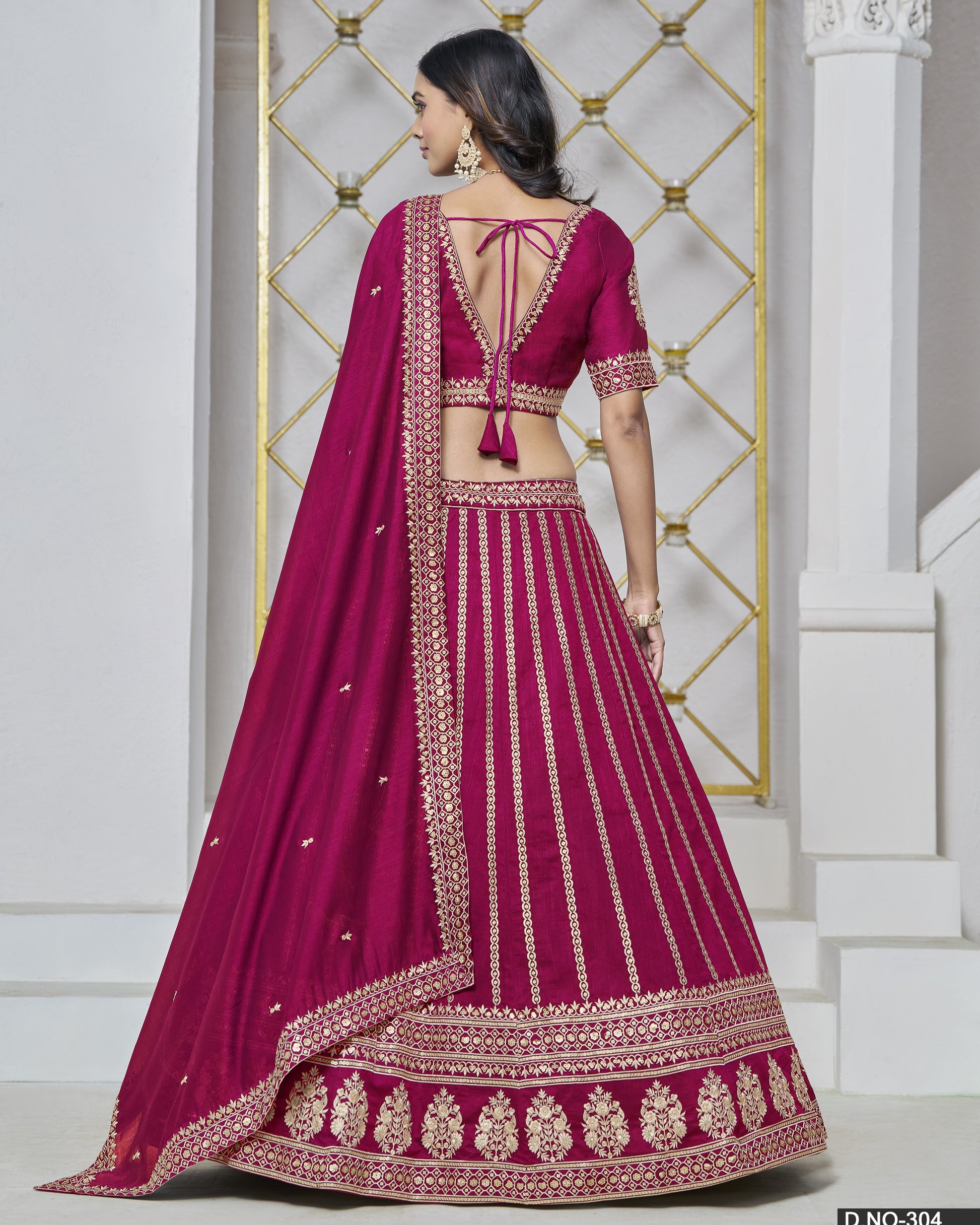 Woman wearing a magenta embroidered traditional outfit with a white background