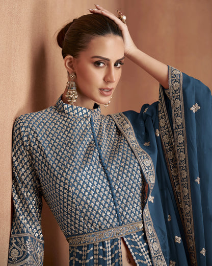 Woman in traditional blue and white embroidered outfit against a beige background
