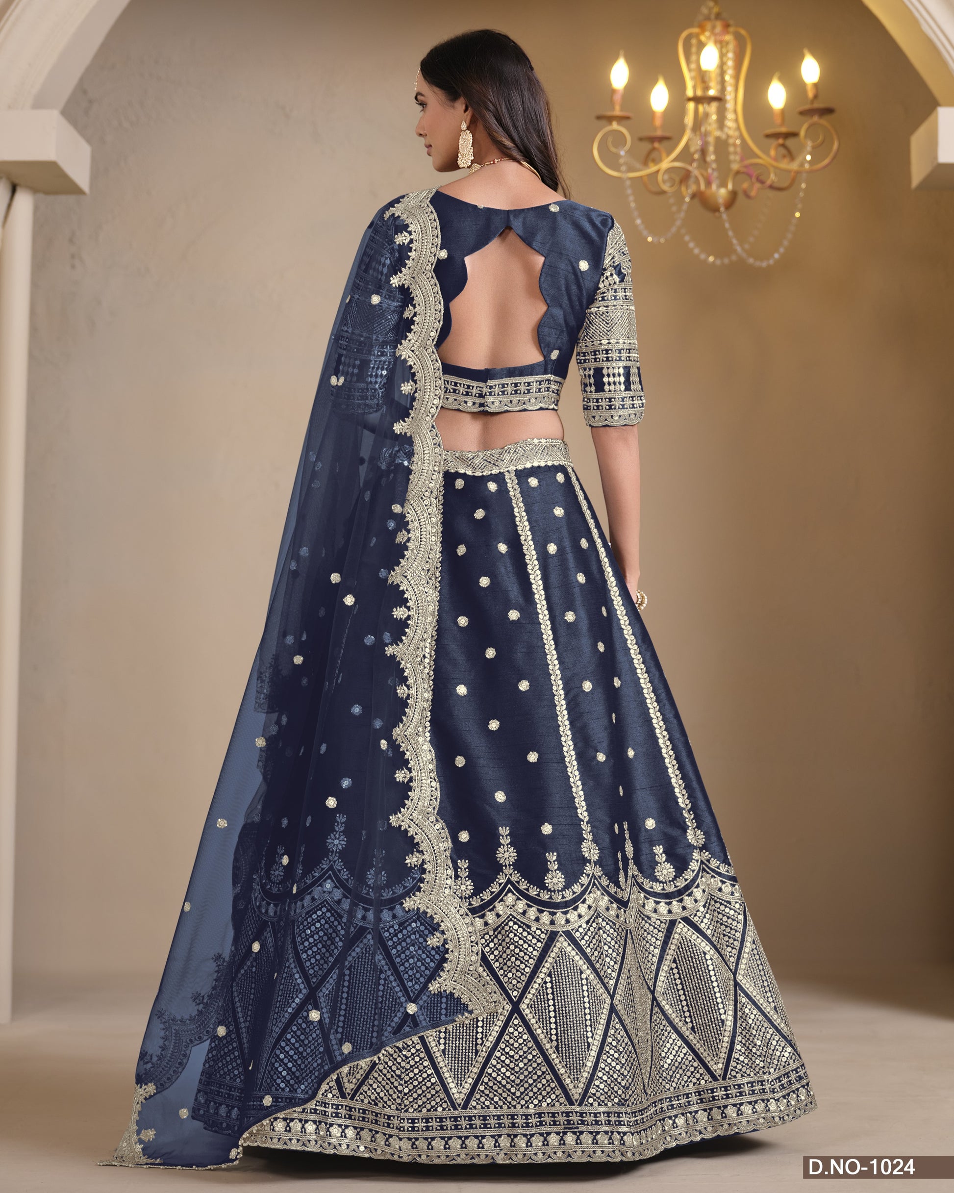 Navy blue embroidered traditional outfit with a chandelier in the background