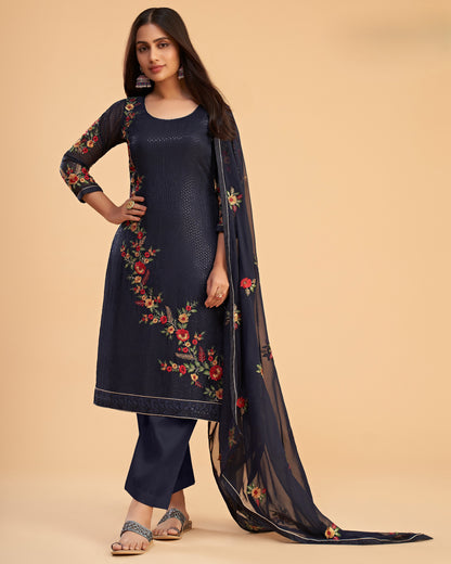 Woman wearing a navy blue embroidered outfit with a beige background