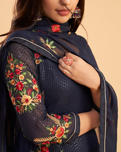 Navy blue embroidered outfit with floral patterns on a beige background