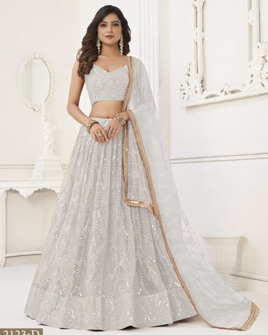 Woman wearing a silver embroidered lehenga in a white room