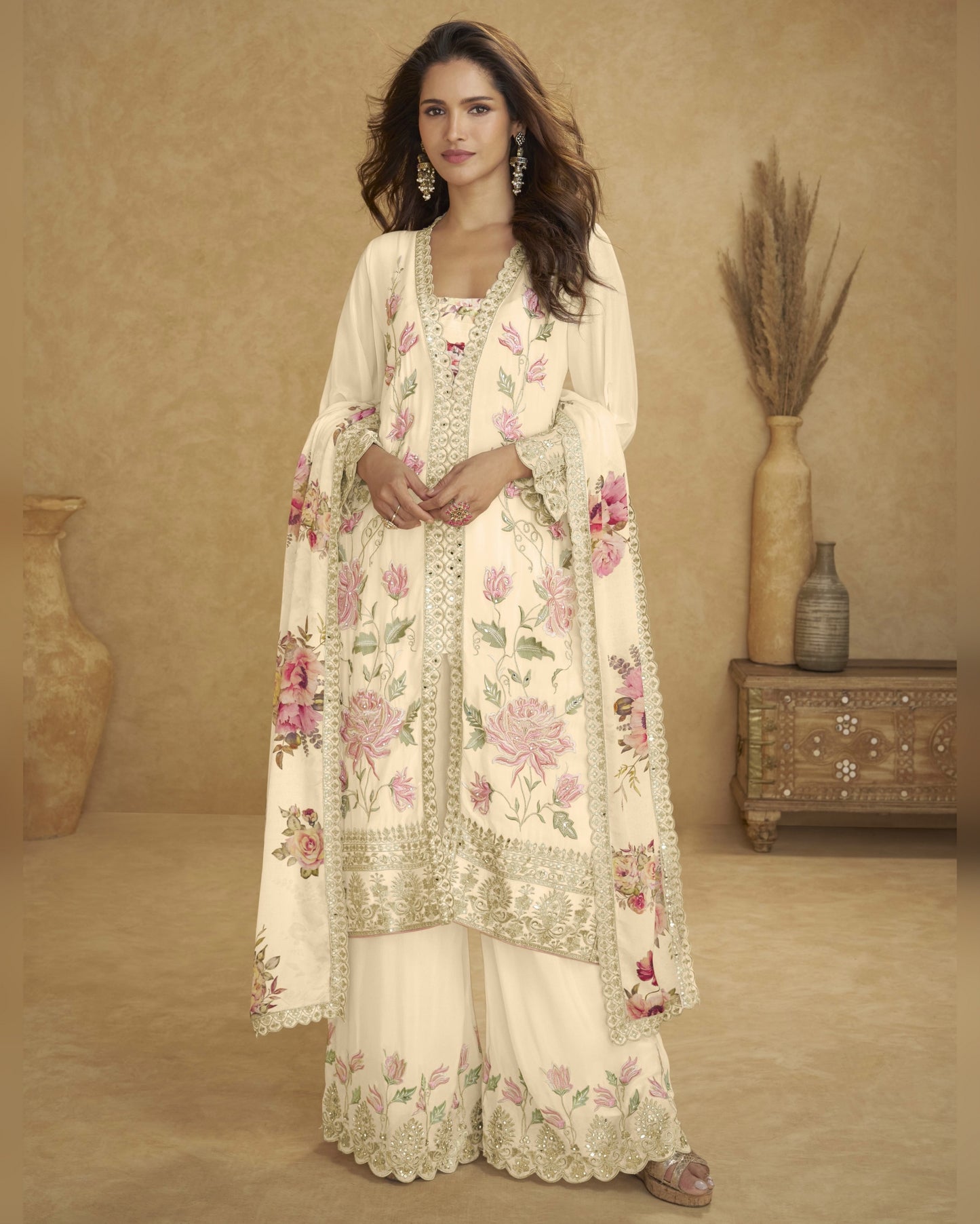 Woman wearing a floral embroidered outfit in a warm-toned room.