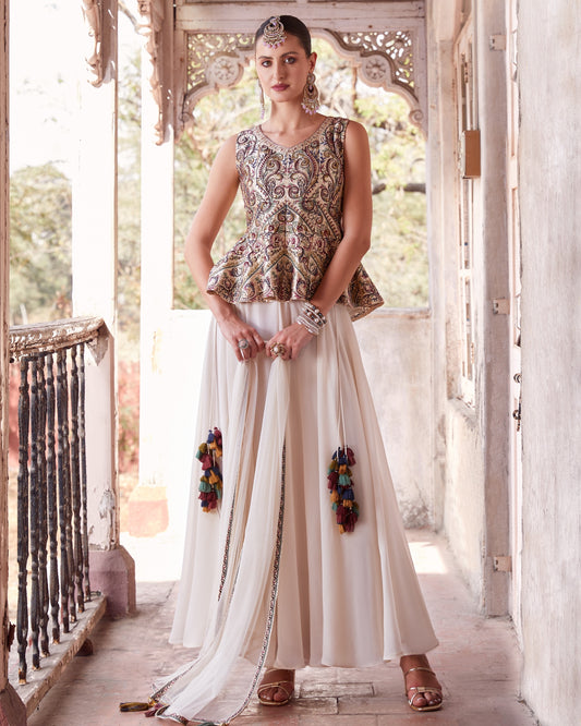 Woman in traditional outfit standing in a decorative doorway.