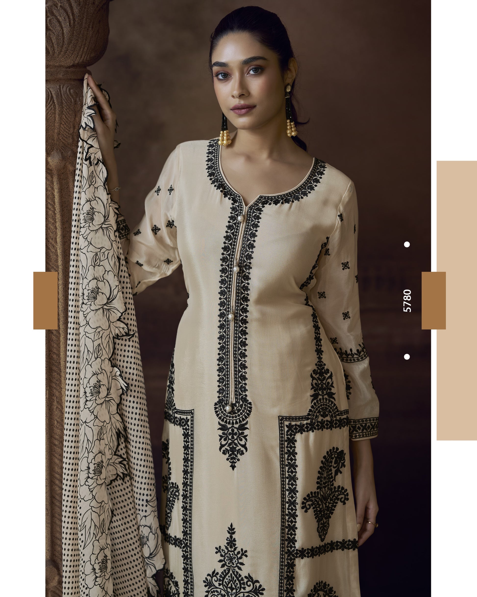 Woman wearing a beige embroidered kurta with black patterns, holding a matching dupatta.