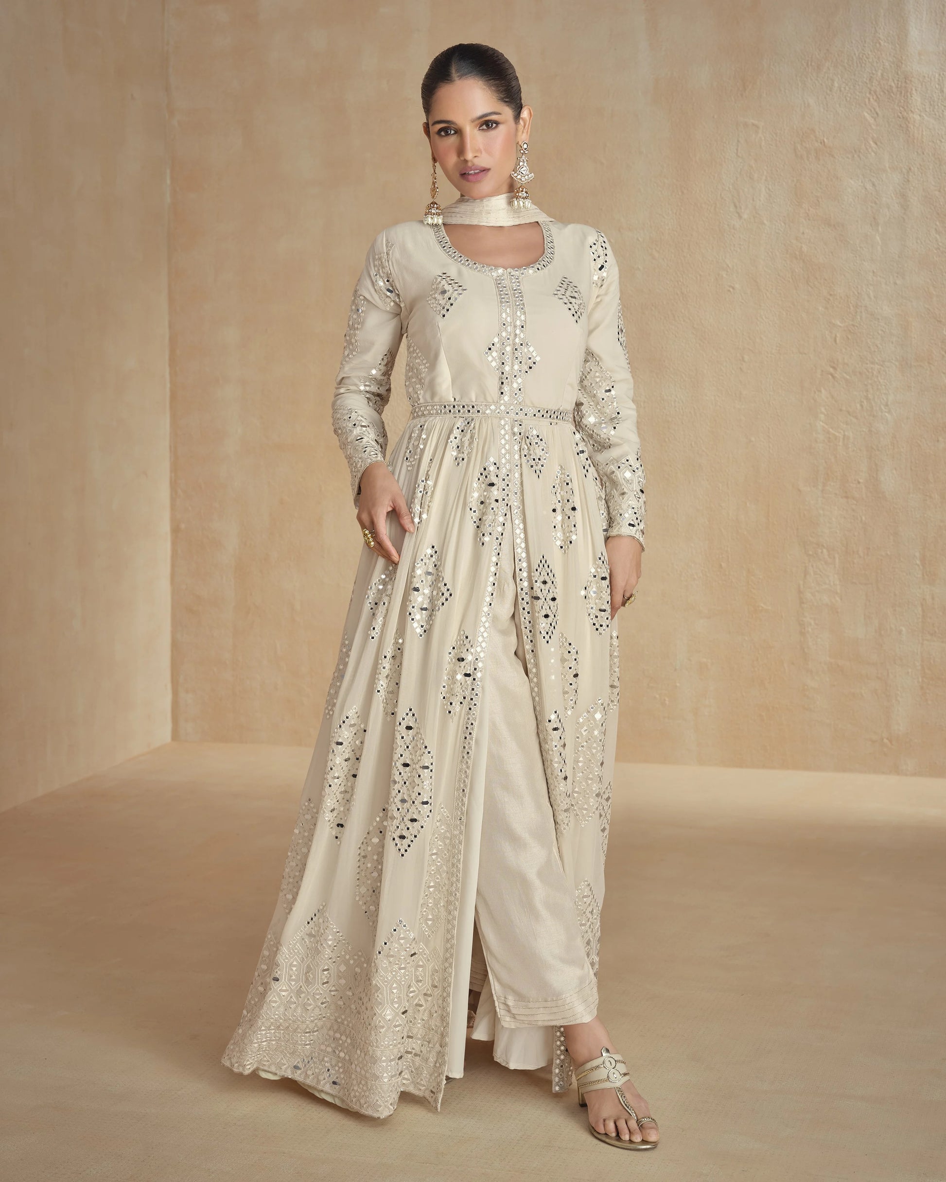 Woman wearing a cream embroidered outfit on a beige background