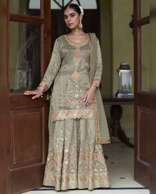 Woman in a traditional embroidered outfit standing in a doorway.