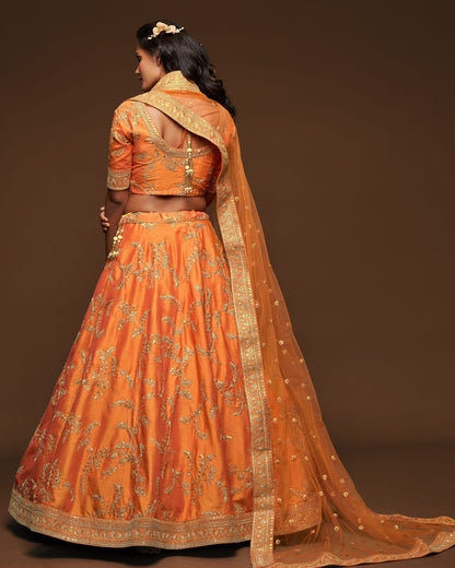 Orange traditional outfit with gold embroidery on a brown background