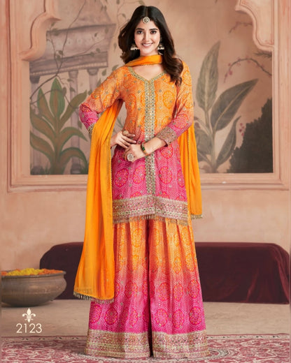 Woman wearing a traditional outfit with orange and pink colors in a decorated room.
