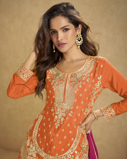 Woman wearing an orange embroidered traditional outfit with a beige background