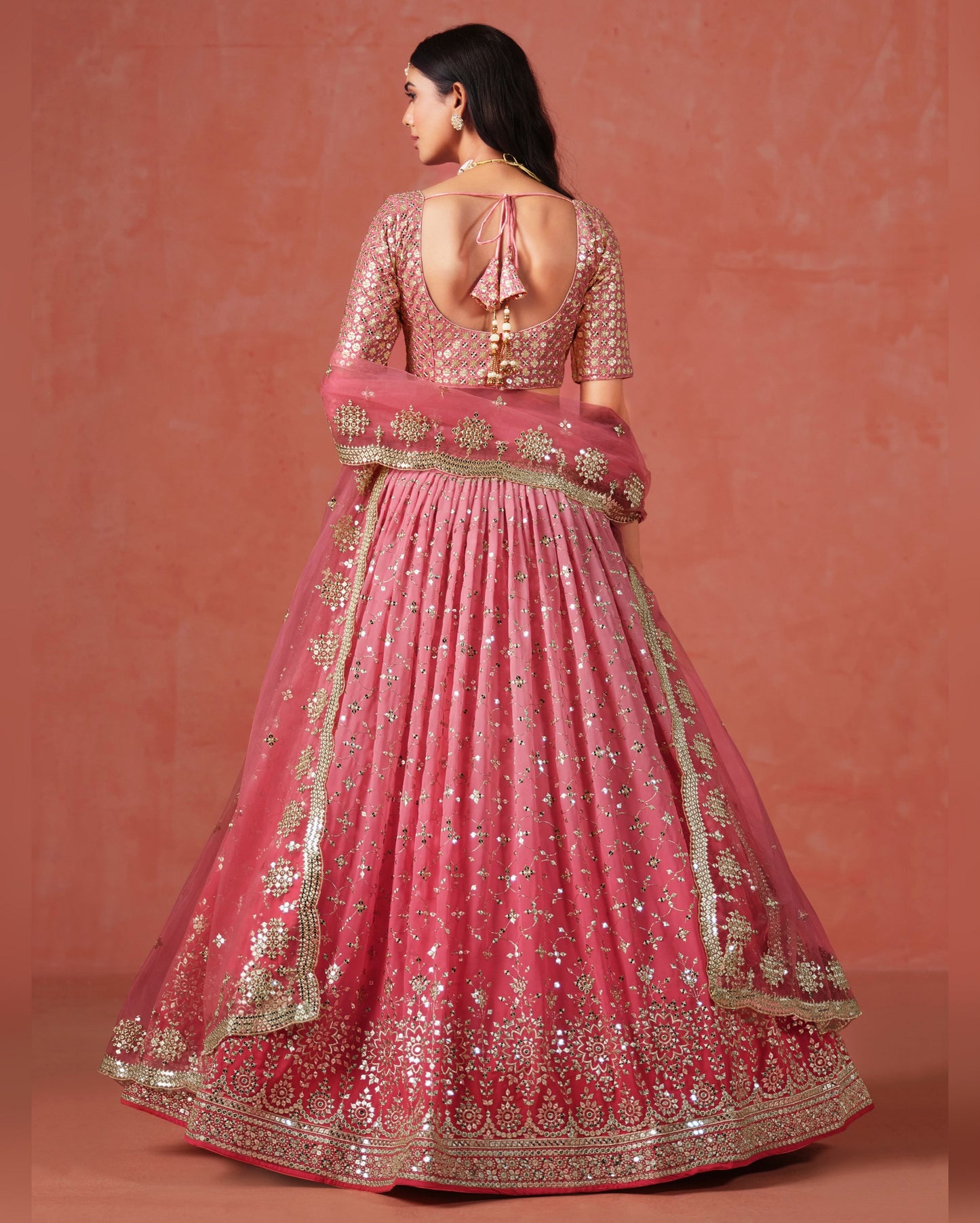 Pink embroidered traditional outfit on a matching background