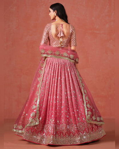 Pink embroidered traditional outfit on a matching background