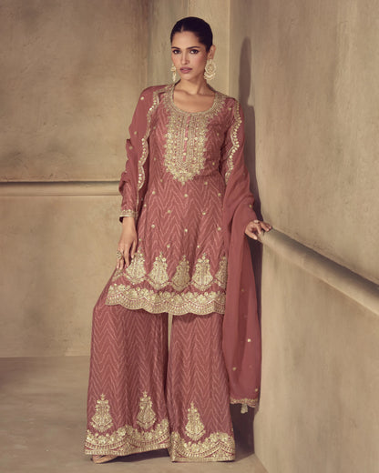 Woman wearing a traditional embroidered outfit against a neutral background