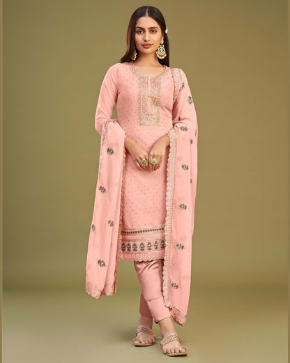 Woman wearing a pink traditional outfit with embroidery on a beige background