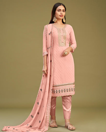 Woman wearing a pink traditional outfit with embroidery on a green background