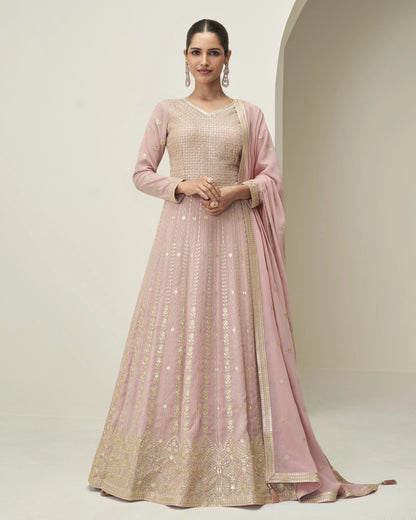 Woman wearing a pink and gold traditional outfit with a plain background