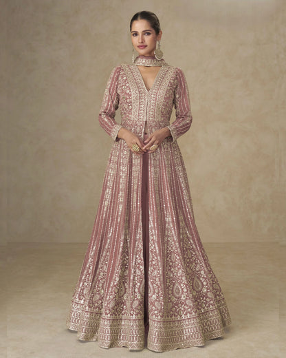 Woman wearing a traditional embroidered dress against a neutral background