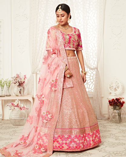 Woman in a pink traditional outfit with floral patterns in a decorated room.
