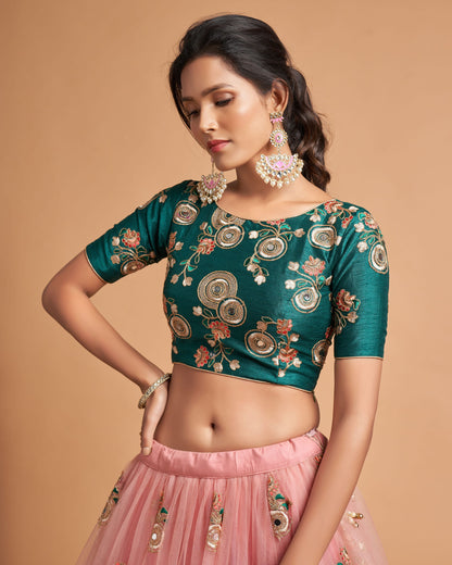 Woman wearing a green embroidered blouse with floral patterns on a beige background