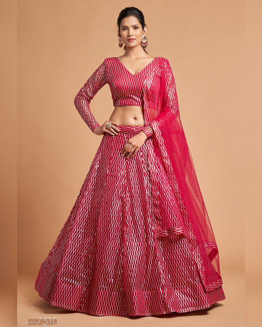 Woman wearing a pink traditional outfit with a sheer dupatta on a beige background