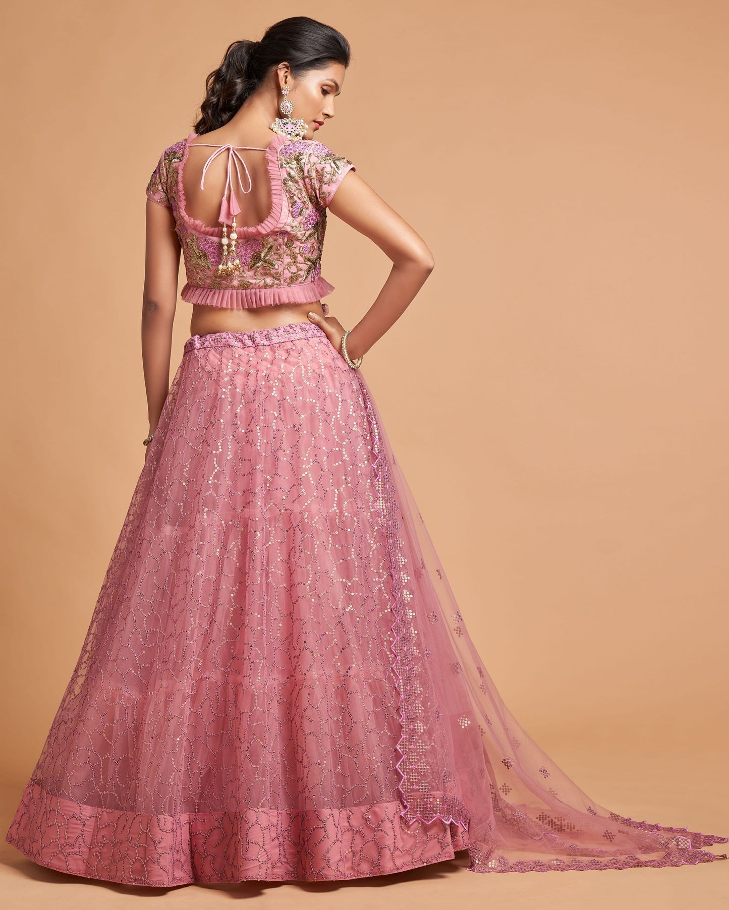 Woman wearing a pink traditional outfit with a beige background