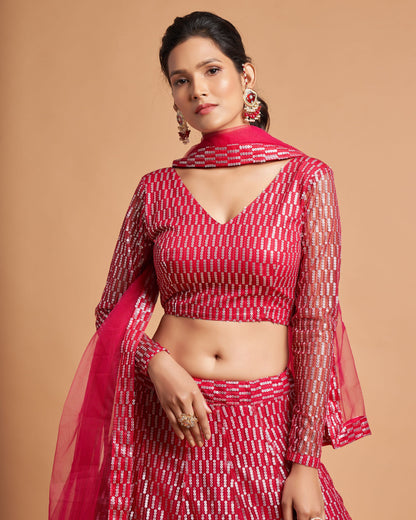 Woman wearing a red and white traditional outfit with a sheer dupatta against a beige background