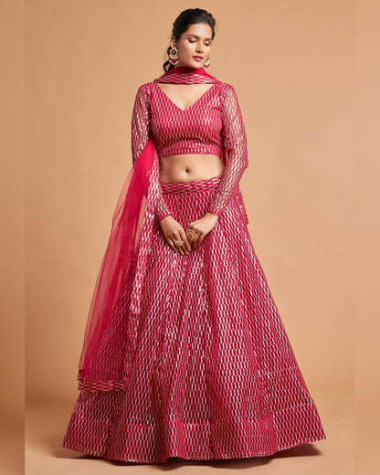 Woman wearing a red and white patterned lehenga with a dupatta on a beige background