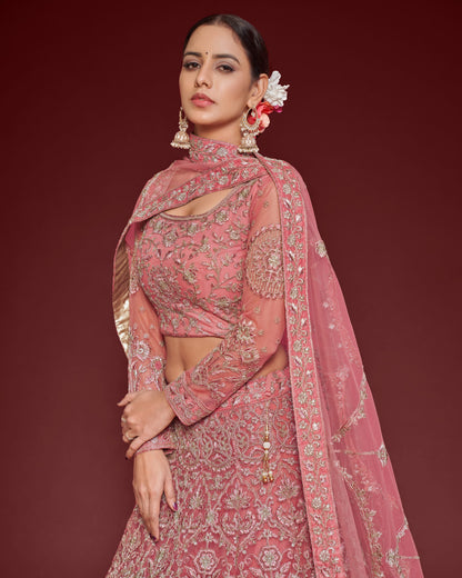 Woman in a pink traditional outfit with intricate designs on a red background