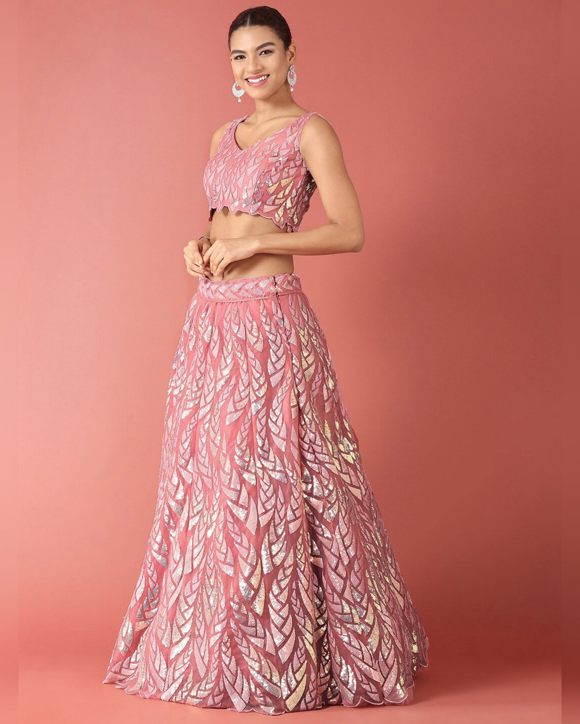 Woman wearing a pink patterned outfit on a pink background