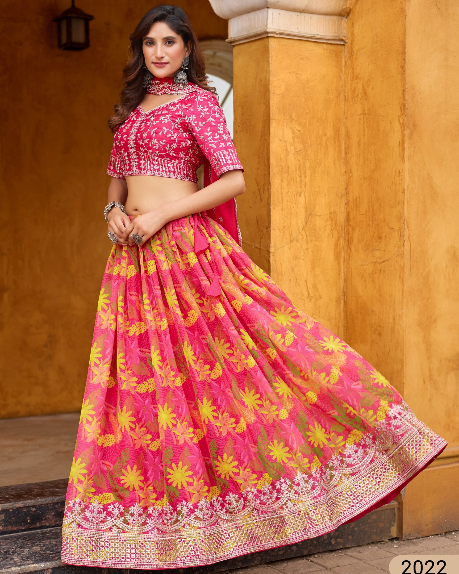 Woman wearing a pink and yellow traditional outfit with a floral pattern.