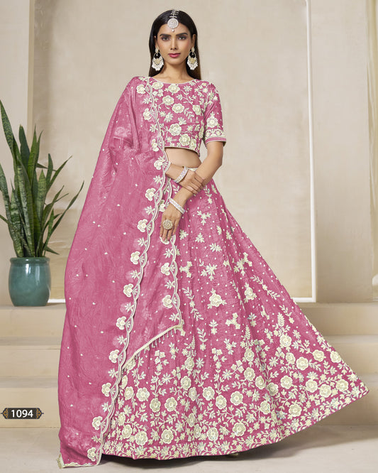 Woman wearing a pink floral saree with a matching blouse in an indoor setting.