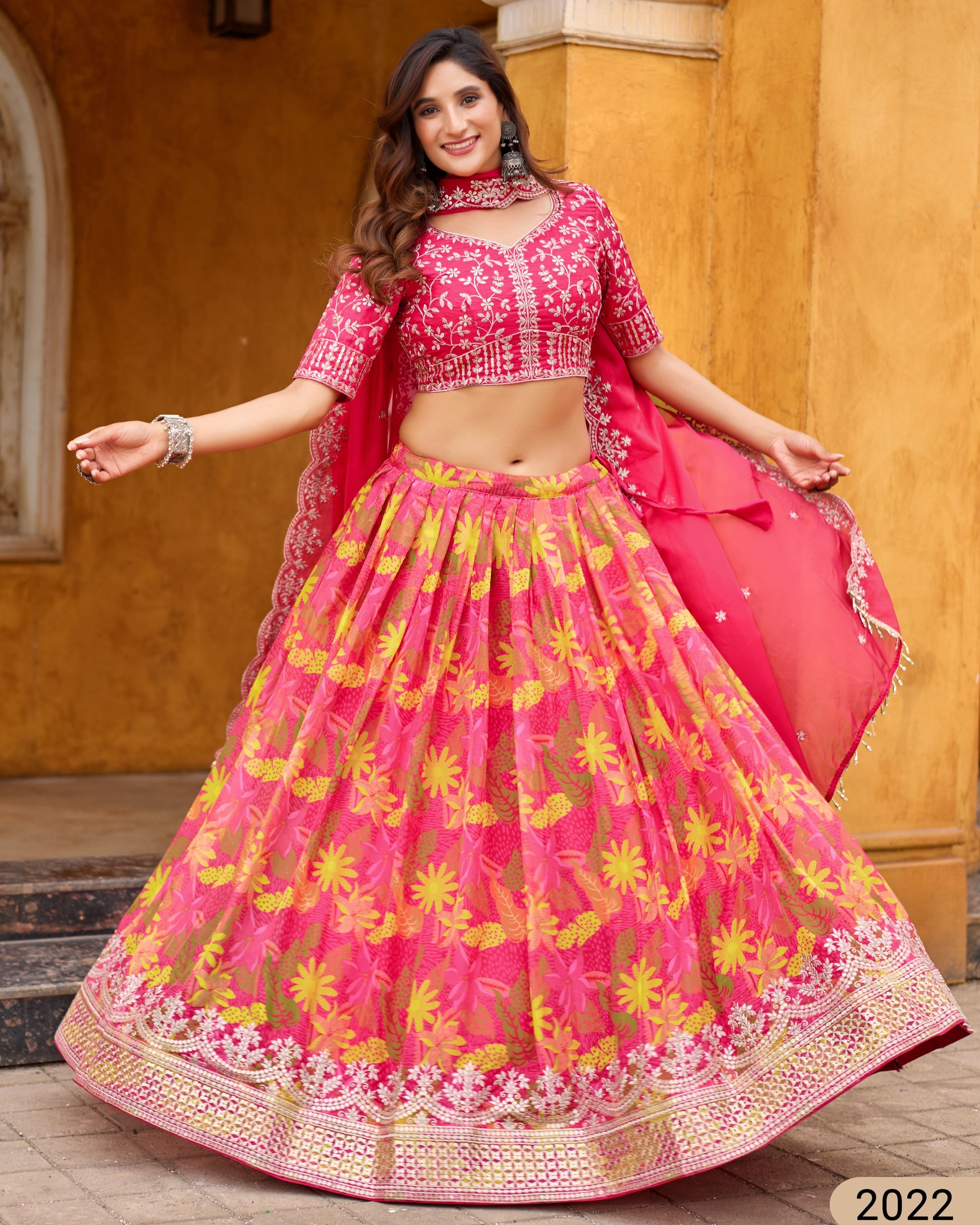 Woman in a pink and yellow traditional outfit with a blurred background