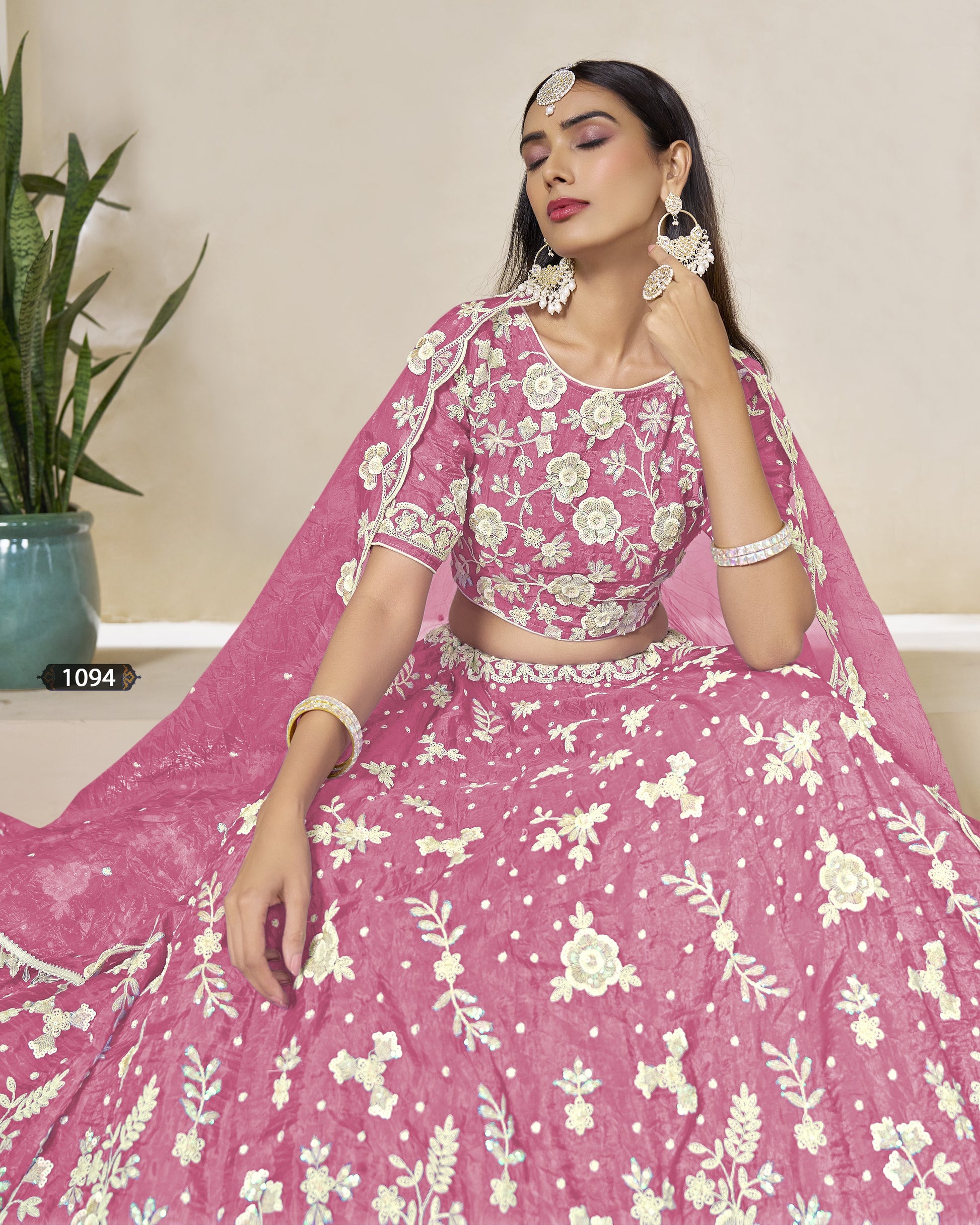 Woman in a pink floral traditional outfit with a neutral background