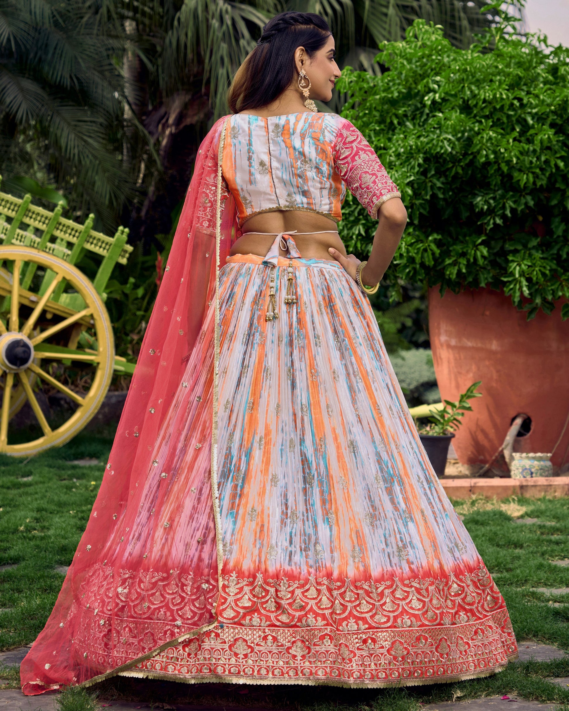 Woman in traditional Indian attire standing outdoors with greenery in the background