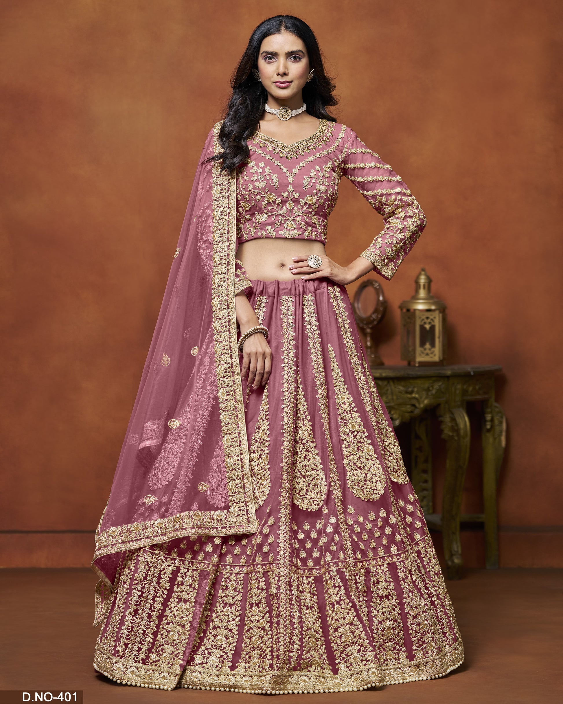 Woman in a traditional pink and gold embroidered outfit against a brown background