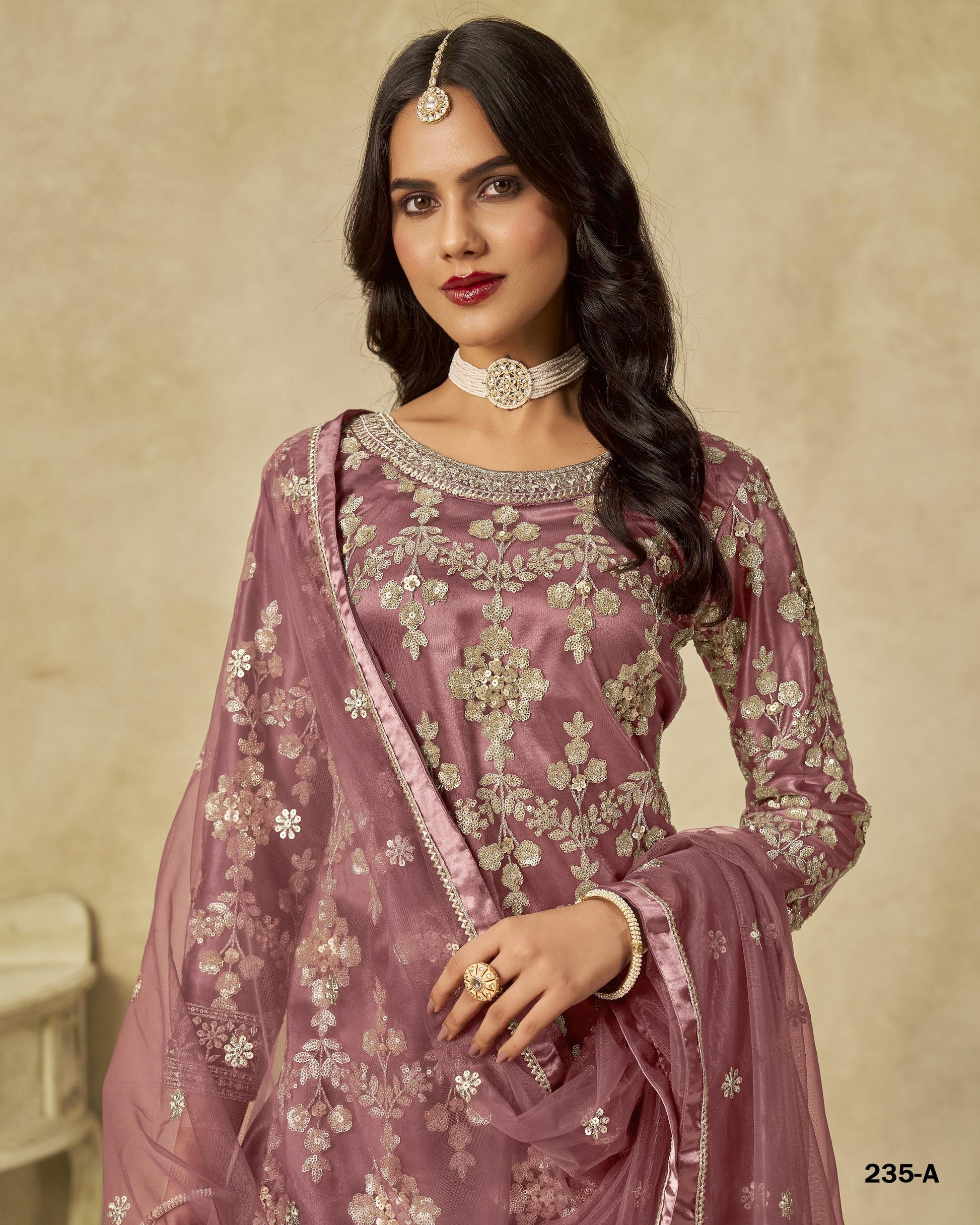 Woman wearing a traditional embroidered outfit with a beige background