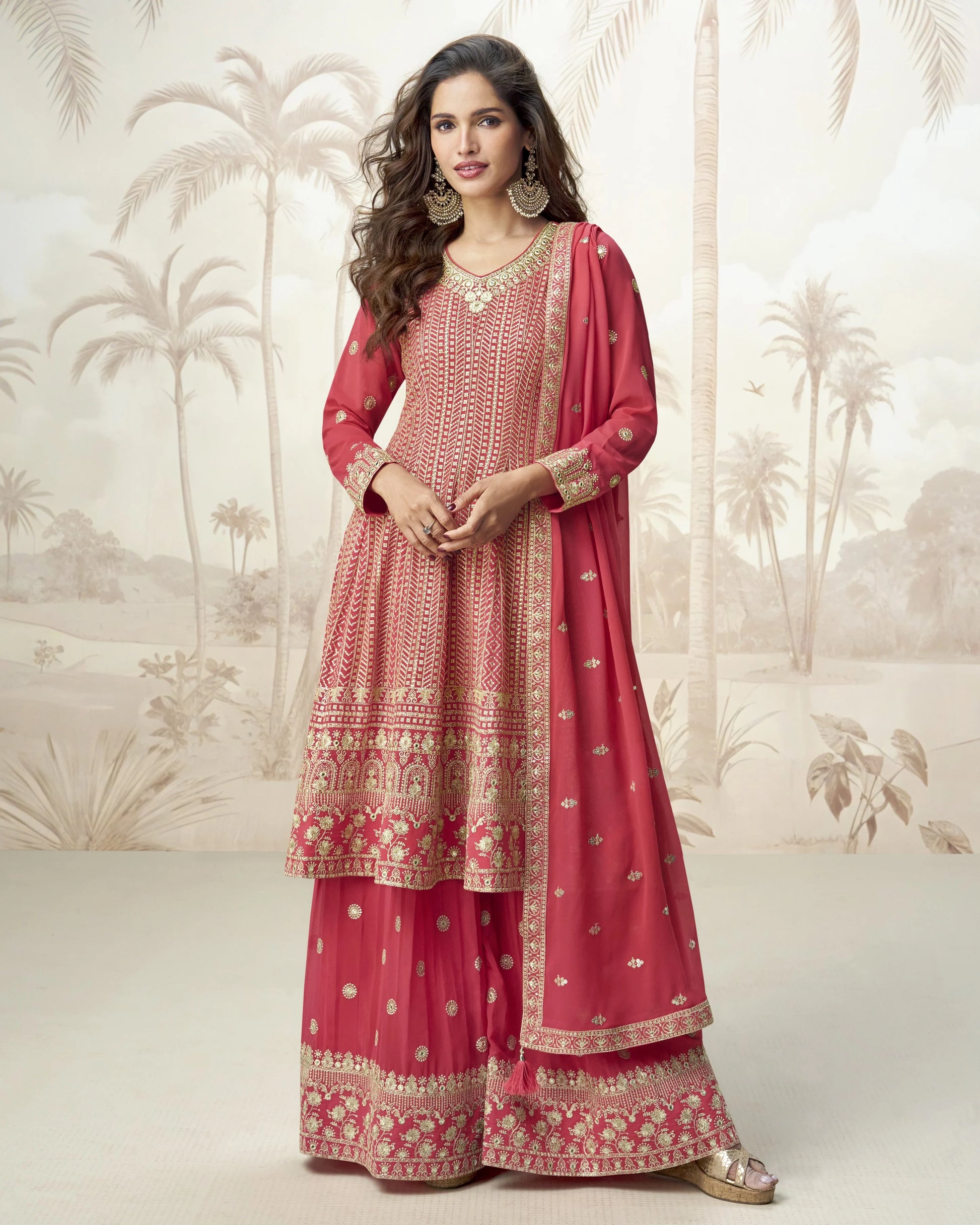 Woman wearing a red and gold traditional outfit with a palm tree patterned background