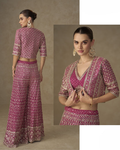 Woman wearing a pink patterned outfit with a blouse and palazzo pants on a beige background.