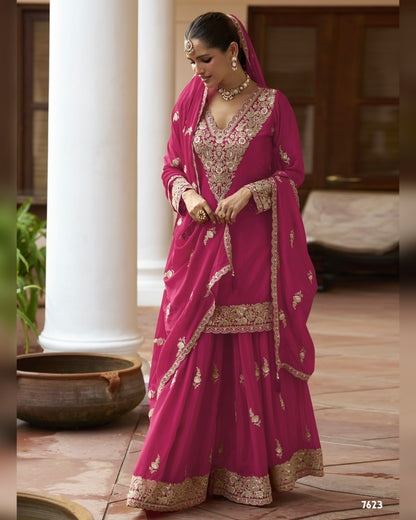 Woman in a traditional pink and gold saree with a blurred background