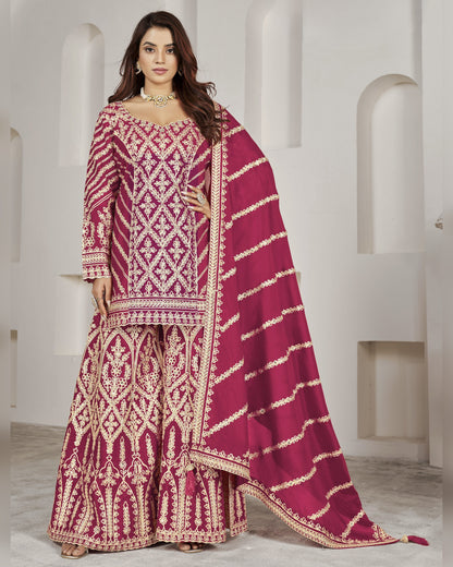 Woman wearing a magenta embroidered traditional outfit with a white background