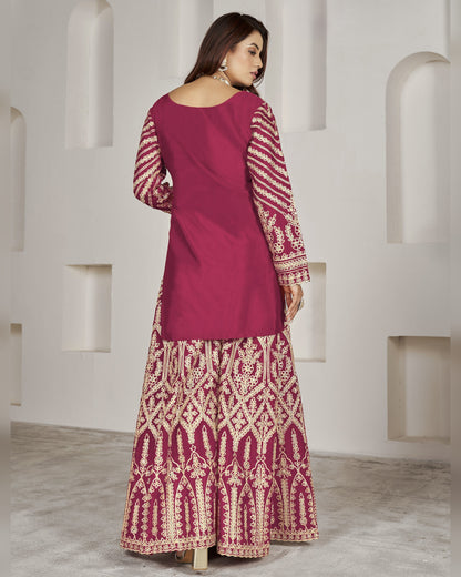 Woman wearing a magenta and white patterned traditional outfit against a white architectural background