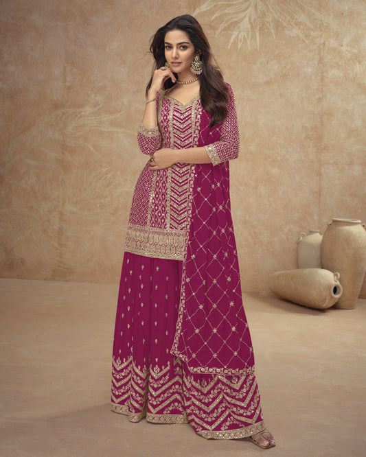 Woman in a pink and gold traditional outfit against a beige background