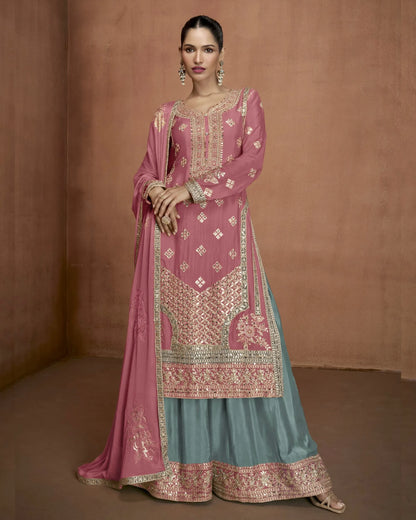 Woman wearing a traditional outfit with pink and blue colors against a brown background