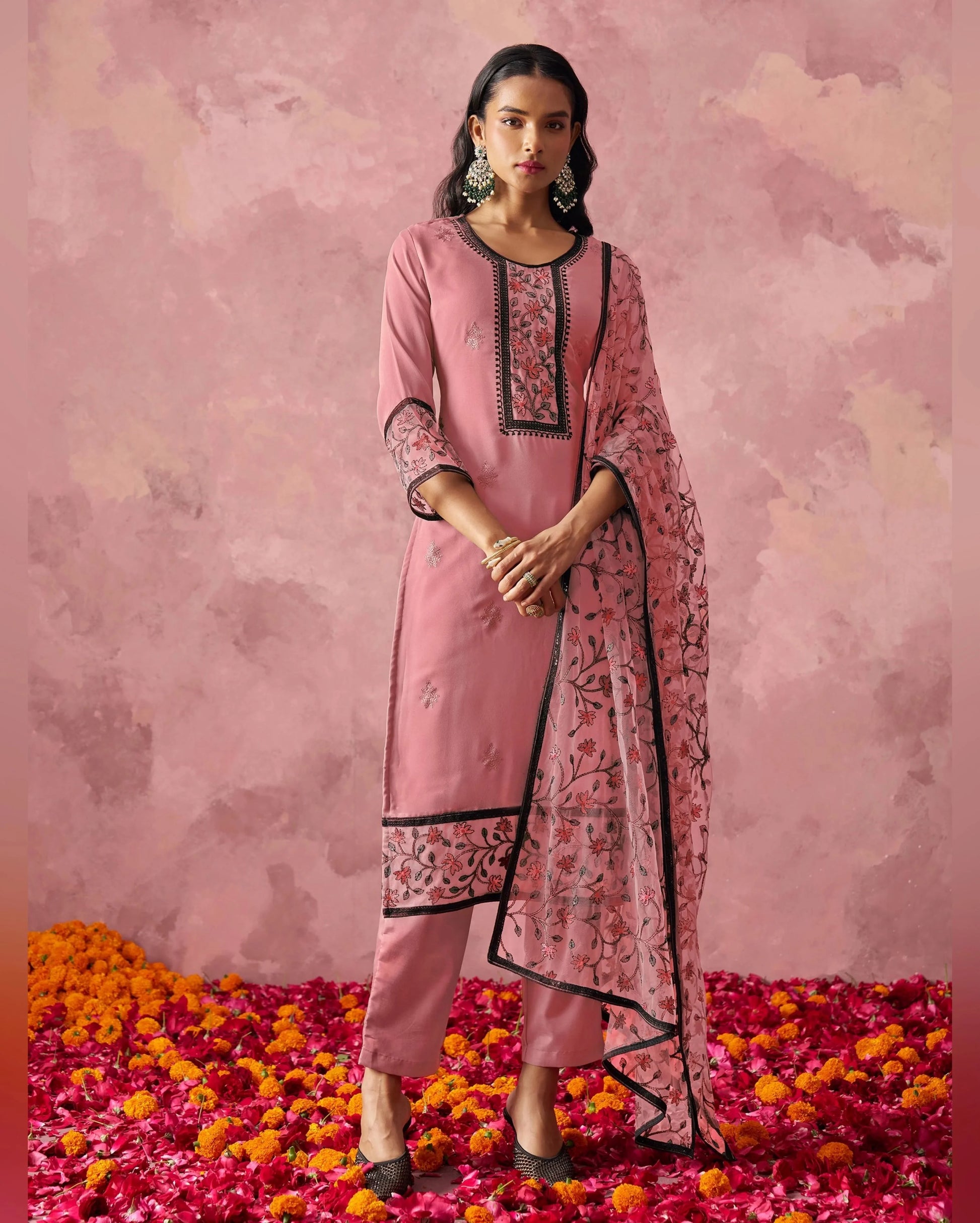 Woman in a pink traditional outfit with a floral pattern on a pink floral background