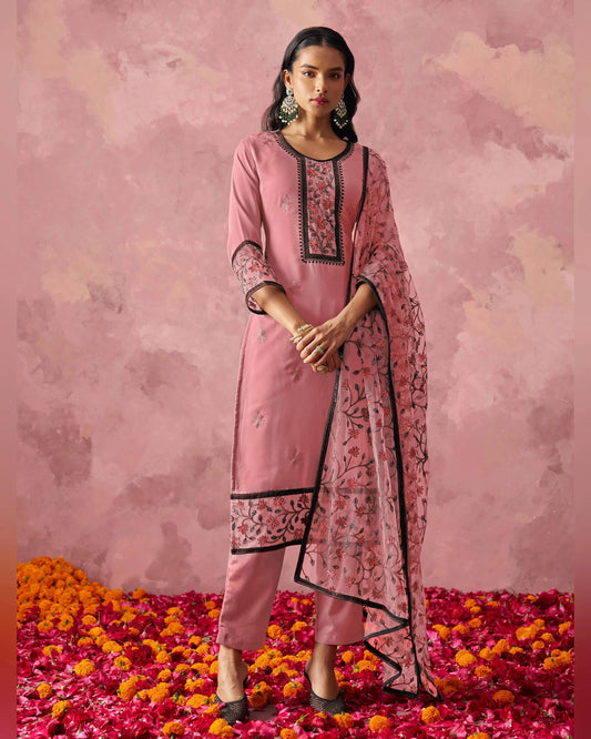 Woman in a pink traditional outfit with a floral pattern on a pink floral background