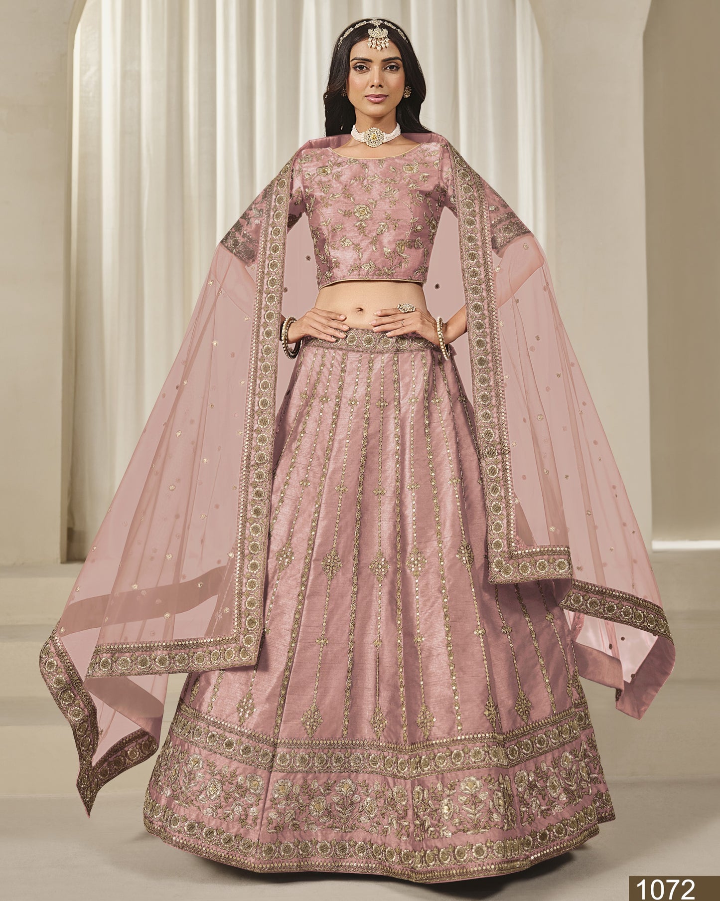 Pink embroidered traditional outfit with a sheer dupatta on a neutral background