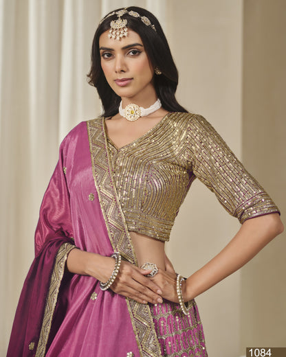 Woman wearing a traditional outfit with a gold blouse and pink saree against a neutral background