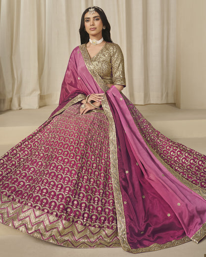 Woman wearing a traditional pink and gold saree with a matching blouse against a neutral background