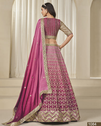 Woman wearing a pink and gold traditional outfit with a patterned skirt in a neutral setting